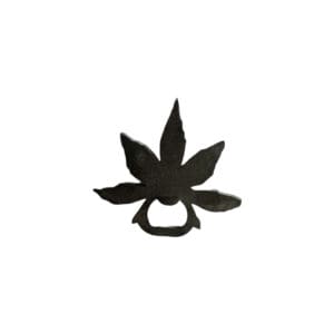 A black leaf shaped bottle opener on top of a white table.